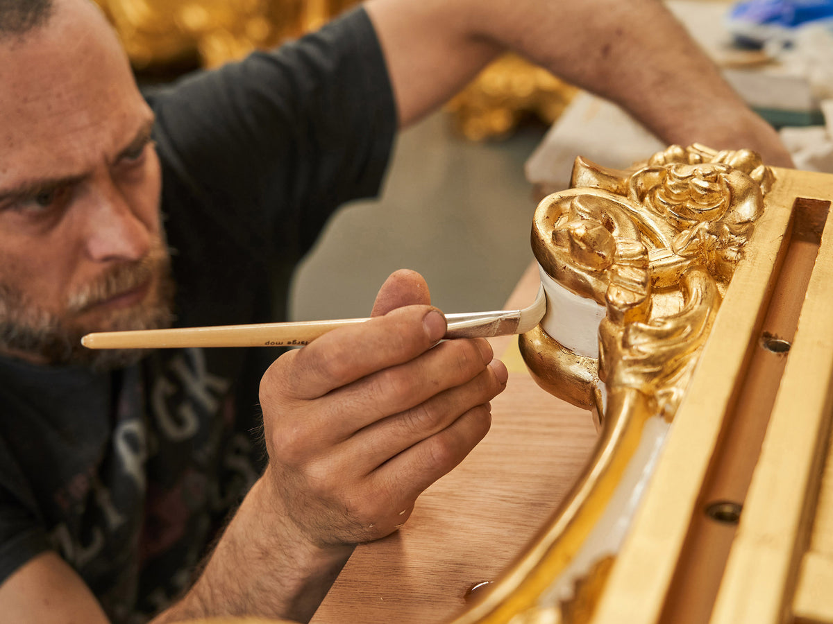 Gilding a carved frame in the workshop